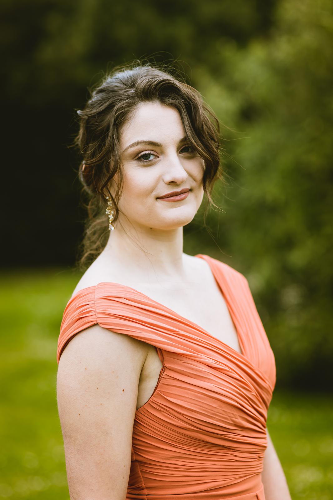 Portrait d'invitée coiffée d'un chignon flou et maquillée pour un mariage