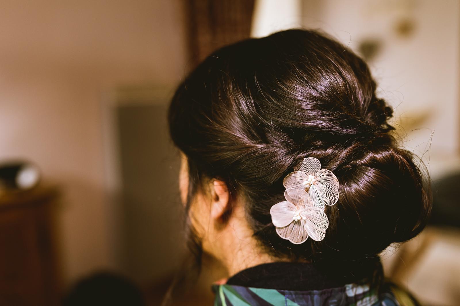 Chignon bas lisse orné de fleurs nacrées, coiffure de mariage Bergerac